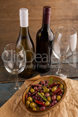 High angle view of wine bottles by olives served in container
