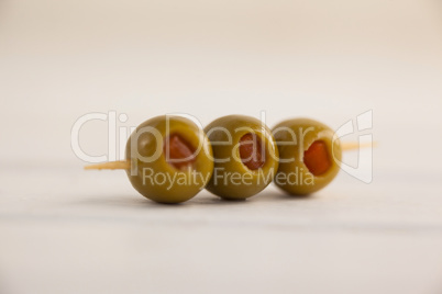 Close up of olives in toothpick on table