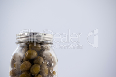 Green olive in glass jar with silver lid