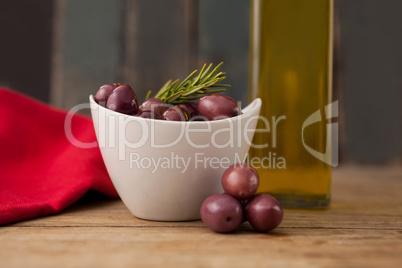Close up of olives in bowl by oil bottle