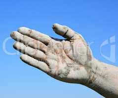 Man's open palm smeared with mud