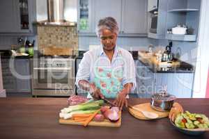 Woman cutting vegetables while preparing food