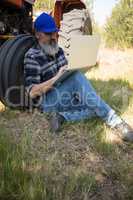 Man using laptop in olive farm