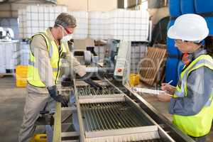 Technicians examining olives on conveyor belt