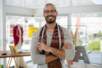 Portrait of smiling male designer with arms crossed in studio