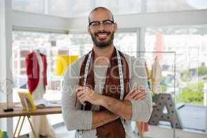 Portrait of smiling male designer with arms crossed in studio