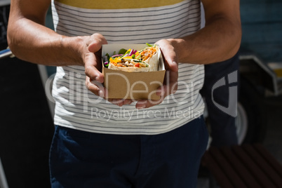 Young man holding tortilla in box