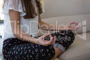 Midsection of businesswoman doing yoga in office
