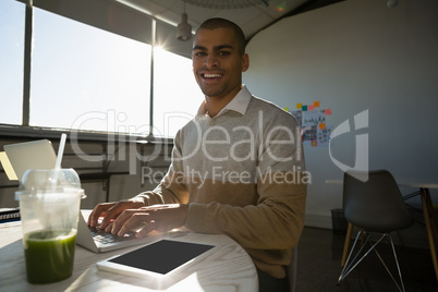 Portrait of man using laptop in offce