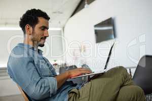 Relaxed man using laptop in office