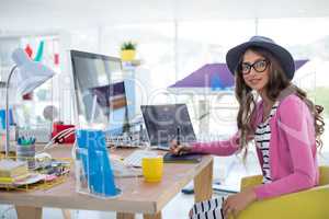 Female graphic designer using graphic tablet at desk