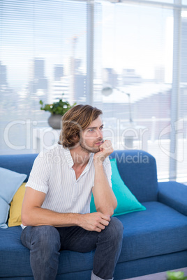 Depressed male executive sitting on sofa