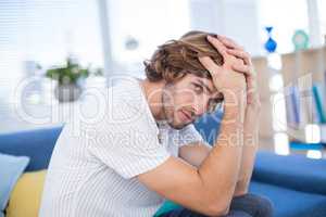 Depressed male executive sitting on sofa