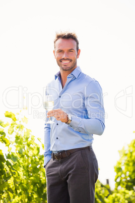 Portrait of smiling young man holding wineglass