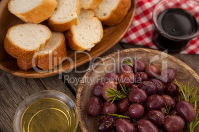 Olives and bread with oil on table