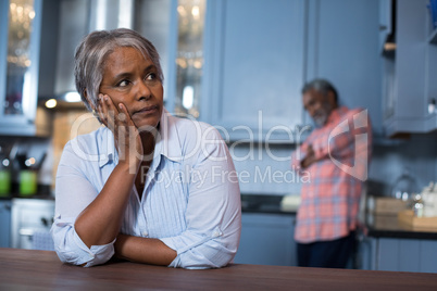 Thoughtful woman with man in background
