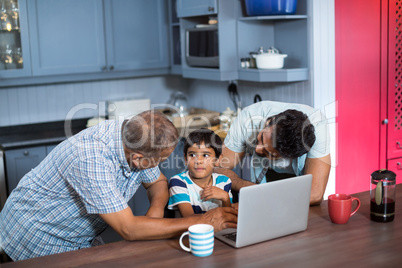 Father and grandfather talking to boy