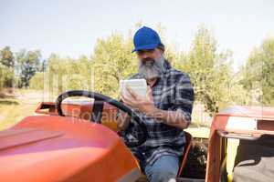 Man using digital tablet in tractor