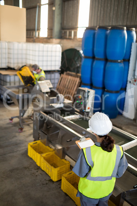 Female technician writing in clipboard