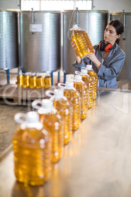 Female worker checking oil bottles