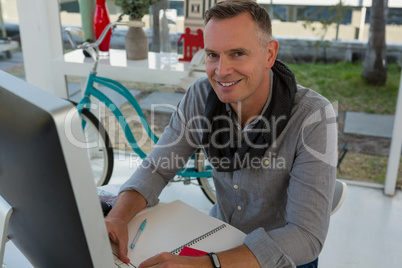 Portrait of businessman sitting at desk in office