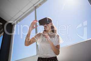 Low angle view of happy businesswoman using virtual reality simulator
