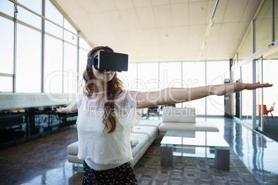 Smiling businesswoman using virtual reality simulator exercising in office