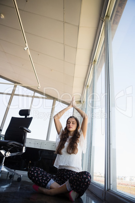 Full length of businesswoman doing yoga