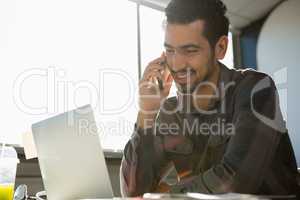 Smiling man talking on phone at office