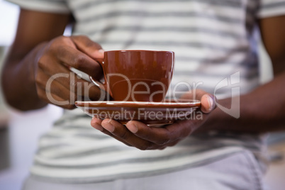 Midsection of man having coffee