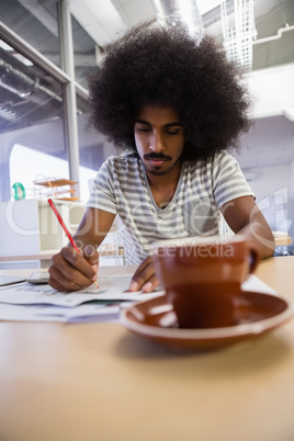 Man writing on document at office
