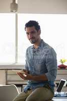 Portrait of man using tablet on desk in office