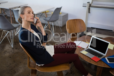 Businesswoman talking on phone in office