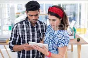 Couple using digital tablet in the office