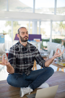 Male executive doing yoga in office