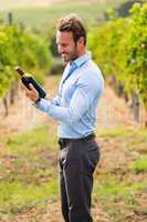 Smiling man holding wine bottle