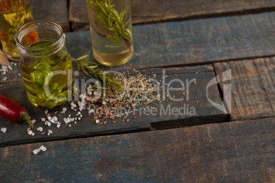 Spices by herb with oil in container on table