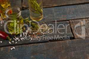 Spices by herb with oil in container on table