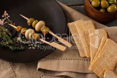 Crackers by green olives served in plate