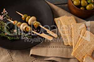 Crackers by green olives served in plate