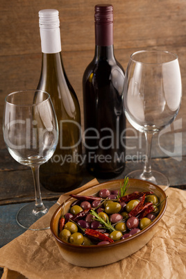 Olives served in container by wine bottles