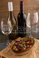 Olives served in container by wine bottles