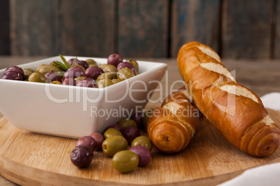 Olives in container by bread