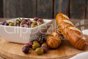 Olives in container by bread