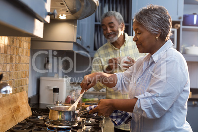 Happy senior couple preparing food home