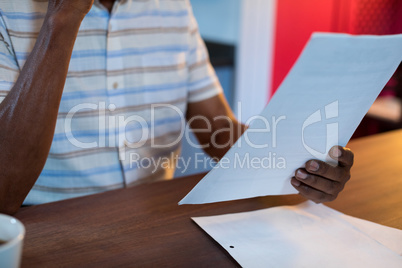 Midsection of man holding paper