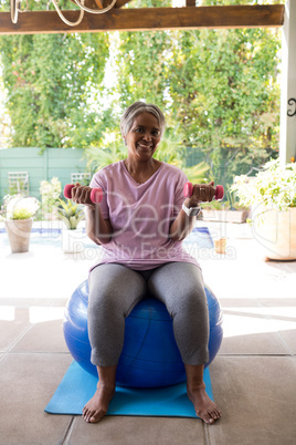 Full length of woman exercising with dumbbells