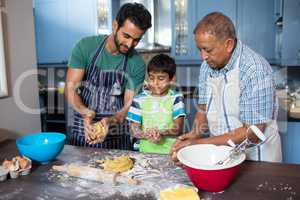 Family holding dough while preparing food