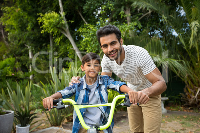 Portrait of father with son sitting on bicycle