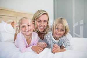 Mother with daughter and son relaxing on bed in the bedroom